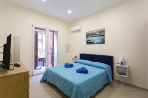 Casa Chicca في باليرمو: غرفة نوم بسرير وملاءات زرقاء وتلفزيون