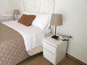 een slaapkamer met een bed met een lamp op een nachtkastje bij CAMERELLE48 in Napels