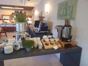 a counter with cups and plates and a coffee maker at Eco Hotel Benacus in Malcesine