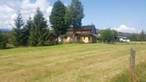 dom pośrodku pola w obiekcie ROZTOKI Four Seasons w mieście Witów