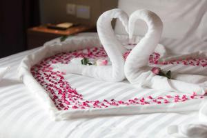 Somewhere Hotel Al Ahsa في الهفوف: كعكة على شكل قلب مع بجعات مصنوعة من الورود