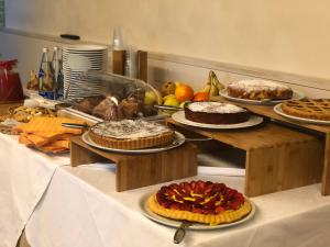 a table topped with cakes and other desserts on plates at Hotel La Foresteria in Abbadia di Fiastra