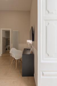 Habitación blanca con escritorio y silla blanca en Five Boutique Rooms, en Nápoles