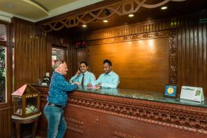 a man standing at a bar with three men at Hotel Encounter Nepal & Spa in Kathmandu