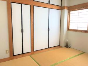 um quarto com portas de vidro deslizantes e um tapete em ゲストハウス奄美ルリカケス em Amami
