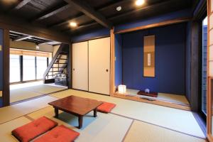 a room with a table and a blue wall at Kanazawa Bettei Yuan in Kanazawa