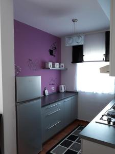 eine Küche mit lila Wänden und einem Kühlschrank in der Unterkunft Apartman Kristian in Velika Gorica