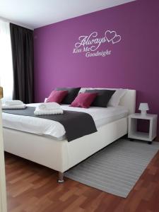 a bedroom with a large bed with a purple wall at Apartman Kristian in Velika Gorica