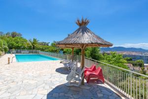 a patio with a umbrella and chairs next to a swimming pool at Appartement vacances cannes in Cannes