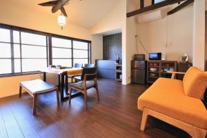 a living room with a couch and a table and chairs at Kanazawa Bettei Yuan in Kanazawa