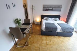 Schlafzimmer mit einem Bett, einem Tisch und einem Schreibtisch in der Unterkunft Apartment Jessica in Mainz