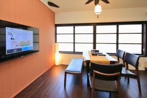 a dining room with a table and a flat screen tv at Kanazawa Bettei Yuan in Kanazawa