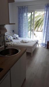 a bedroom with a bed with a sink and a window at Studio Udica in Podgora