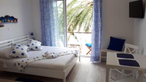 a bedroom with a bed and a large window at Studio Udica in Podgora