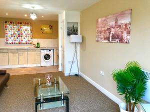 a living room with a table and a kitchen at 2 Bedrooms Modern Apartment, Lounge, Full Kitchen, Balcony, 5 minutes Stratford Station in London