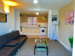 a living room with a couch and a table at 2 Bedrooms Modern Apartment, Lounge, Full Kitchen, Balcony, 5 minutes Stratford Station in London