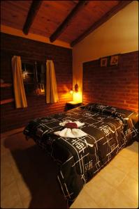 a large bed in a room with a brick wall at Complejo de Cabañas Tierra Nuestra in Mina Clavero