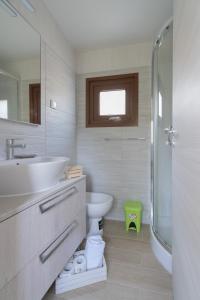 uma casa de banho com um lavatório, um WC e um chuveiro em Camping Lacona em Capoliveri