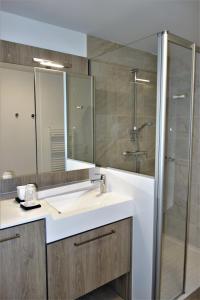 un baño con lavabo y ducha en Domitys - Les Robes d'Airain, en Caen