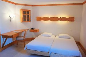 Voodi või voodid majutusasutuse Hôtel Ecureuil Villars toas