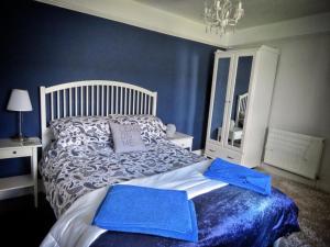 a bedroom with a bed with a blue wall at 2 Emma Place in Bodmin