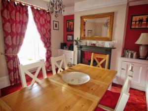 a dining room with a wooden table and a fireplace at 2 Emma Place in Bodmin