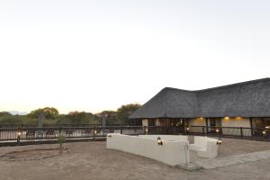 a large building with a black roof and a building at Wildlife Estate House With Mountain Views & 12-Meter Pool in Hoedspruit