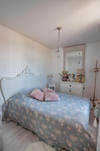 a bedroom with a bed with two pink pillows on it at Vue Mer Côte de Granit Rose en Bretagne in Trébeurden