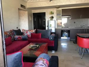 een woonkamer met een rode bank en een keuken bij MCL Majorelle Appartement in Marrakesh