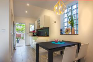 a dining room with a black table and white chairs at Apartments Birimac in Pula