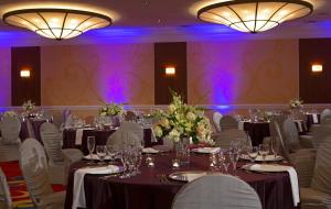 a ballroom with tables and chairs with purple lighting at Wyndham Cleveland Airport in Cleveland +23 photos