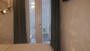 - une chambre avec un lit et une porte en verre avec un balcon dans l'établissement Room Del Giglio, à Bari
