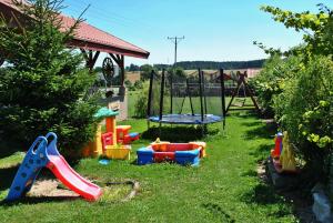 a yard with a playground with a slide and a swing at Domki U Tarnawy in Polanica-Zdrój