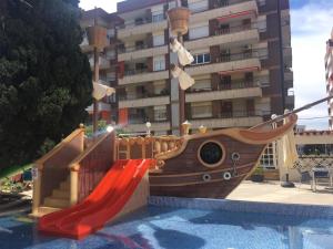 a playground in front of a building with a slide at Hotel Bon Repos in Calella