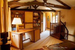 sala de estar con escritorio y estante de libros en La chambre la Tricherie, en Crastes