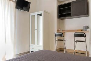 タオルミーナにあるCasa indipendente Terra mia taorminaのベッドルーム1室(椅子2脚、キャビネット、テレビ付)