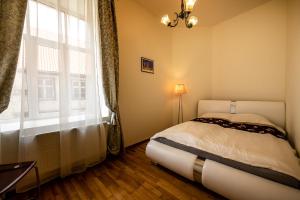 Un dormitorio con una cama y una ventana grande. en Concert Hall, en Liepāja