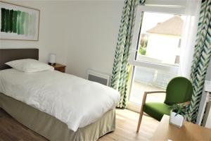 Un dormitorio con una cama y una silla y una ventana. en Domitys - Les Robes d'Airain, en Caen 32 fotos más