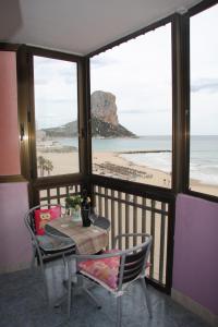カルプにあるPrimera Linea de Playa con Garajeのビーチを望むバルコニー(テーブル、椅子付)