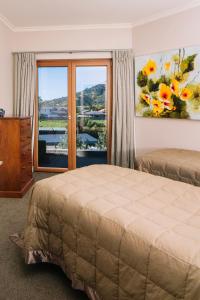 a bedroom with a bed and a large window at Wilkes Way Villa in Picton