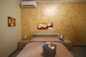 a bedroom with a bed with two night stands and a painting at B&B Cavirani in Gallipoli