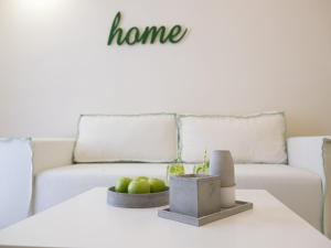 a table with a couch and a bowl of apples on it at Eva Mare Hotel & Suites - Adults only in Agia Pelagia