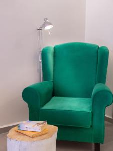 a green chair sitting next to a table with a coffee table sidx sidx at Eva Mare Hotel & Suites - Adults only in Agia Pelagia