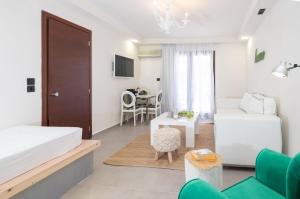 a bedroom with a bed and a living room at Eva Mare Hotel & Suites - Adults only in Agia Pelagia