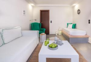 a living room with a couch and a table at Eva Mare Hotel & Suites - Adults only in Agia Pelagia