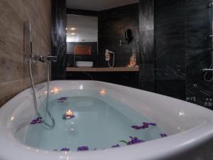 a bathroom with a bath tub with candles in it at Eva Mare Hotel & Suites - Adults only in Agia Pelagia