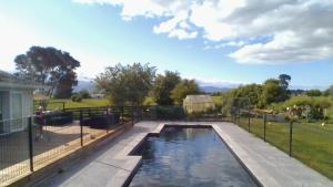 a swimming pool in a yard with a fence at Waihakeke Cottage in Carterton