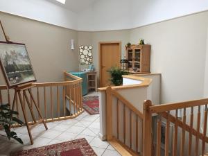 a living room with a staircase and a painting at Villa "Auszeit" in Hohen Neuendorf
