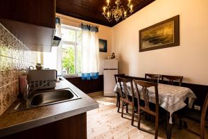 a kitchen with a sink and a table with chairs at Jurnieku nams in Liepāja