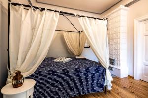 a bedroom with a bed with a canopy at Jurnieku nams in Liepāja